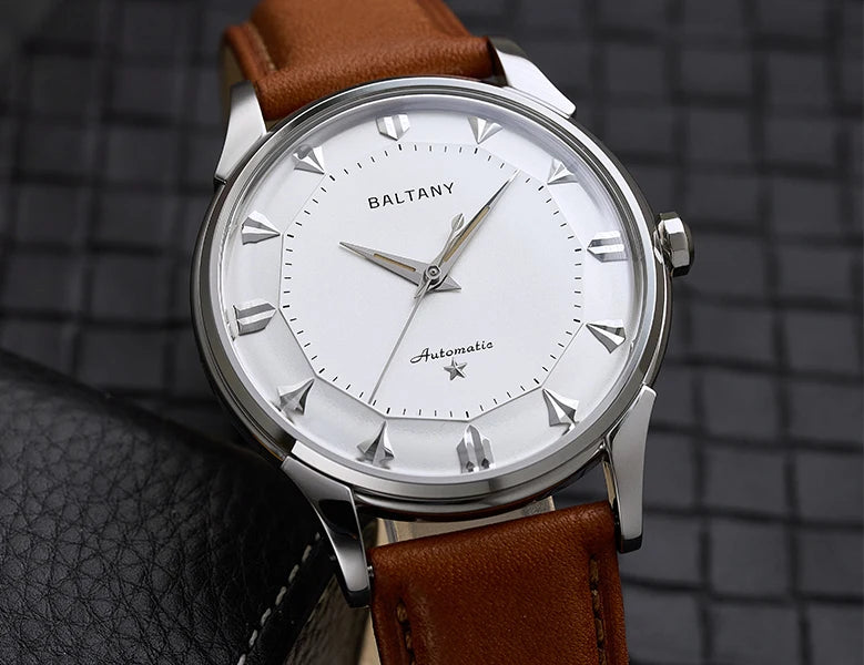 NorthChrono stylish automatic wristwatch featuring a white dial with silver-tone hour markers and hands, brand name "BALTANY" above the center, brown leather strap, and a textured background.