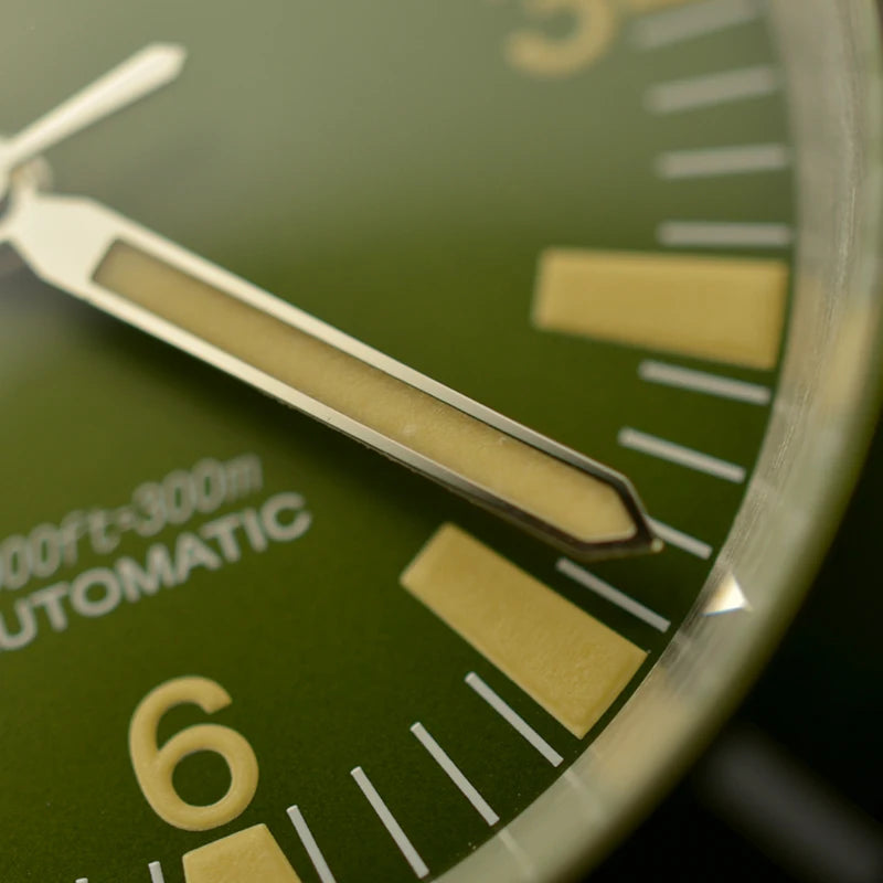 NorthChrono automatic watch close-up featuring a green dial with yellow markers, date indicator, luminous hour and minute hands, and water resistance marking of "1000 ft – 300 m.