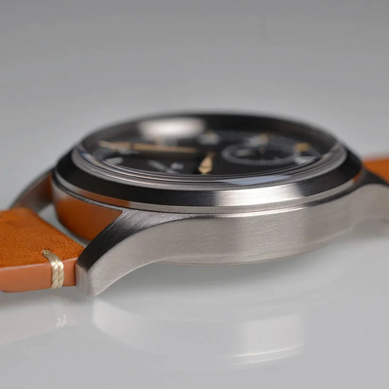 NorthChrono close-up of a modern black dial watch with a polished stainless steel case, metallic accents, and an orange leather strap, possibly featuring sub-dials, showcasing a sleek design.