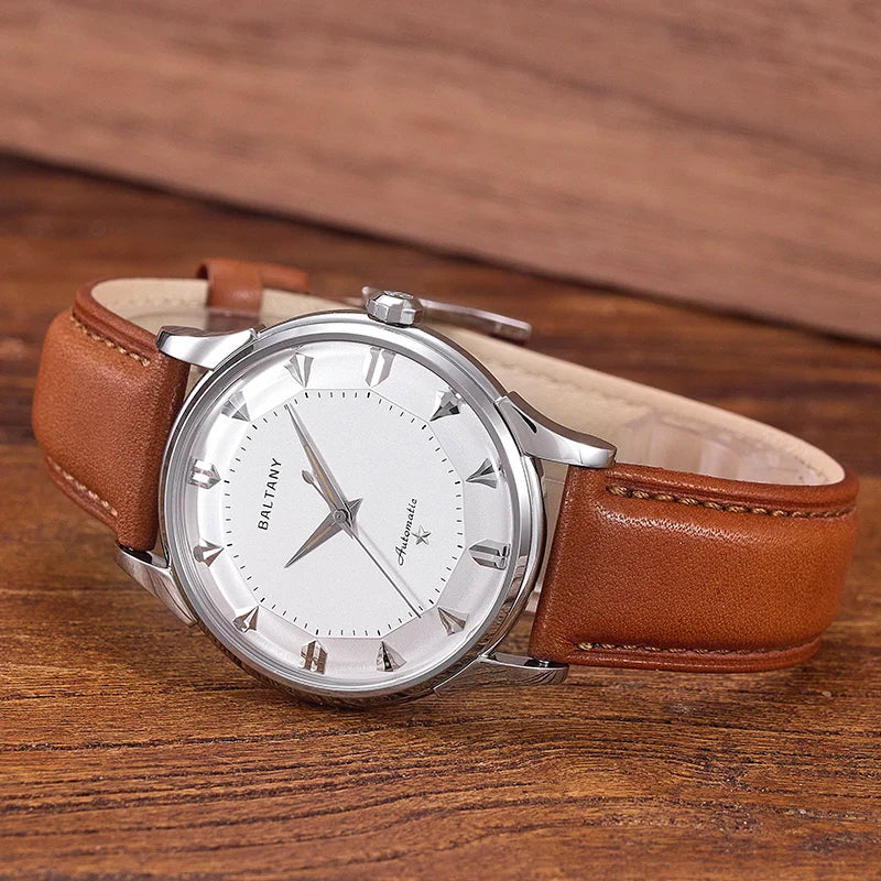 NorthChrono round silver case watch features a white dial with silver markers and hands, mounted on a brown leather strap, against a contrasting wooden surface background.