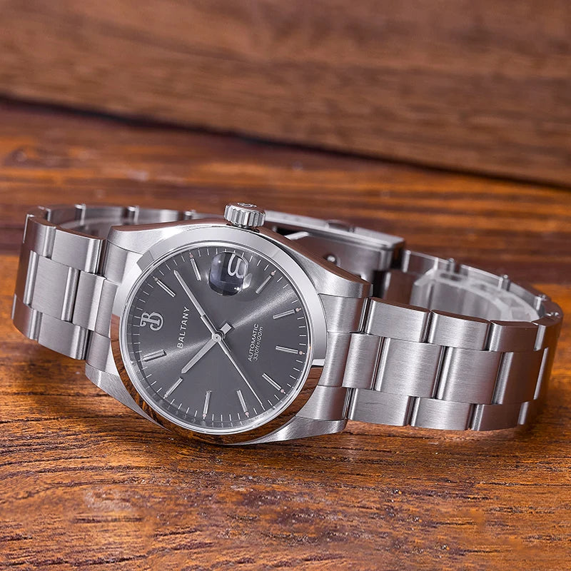 NorthChrono silver stainless steel watch with a dark dial, round case, and polished brushed metal finish. Features a date window and a metal band, set against a wooden background, suitable for both casual and formal wear.