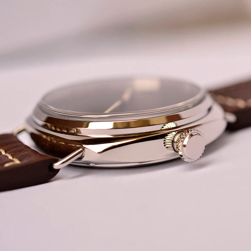 NorthChrono elegant classic watch close-up features a shiny stainless steel case, dark dial with luminous hands, and a brown leather strap. The design includes a crown on the side for setting the time, enhancing its sophisticated appearance.