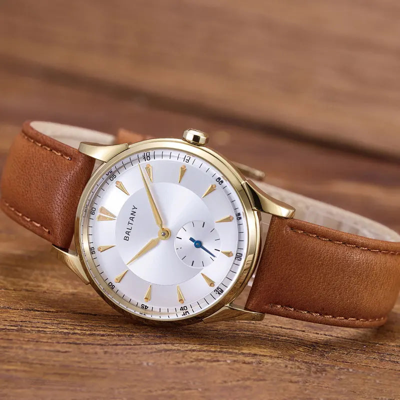 NorthChrono BALTANY watch featuring a classic white dial with gold accents, distinct hour markers, and a sub-dial, complemented by a brown leather strap, set against a wooden surface background.