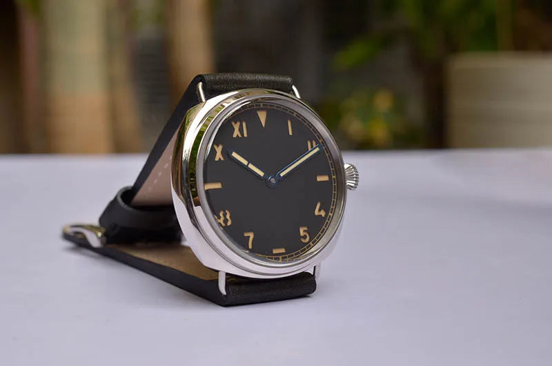 NorthChrono wristwatch featuring a black dial with bold Roman numeral hour markers and a blue second hand, housed in a silver case. The black leather strap complements its elegant design, displayed on a flat surface.