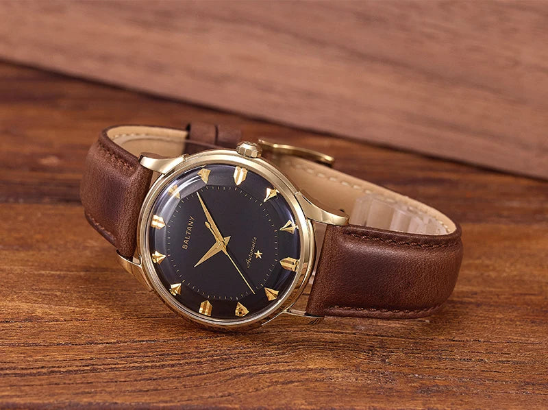 NorthChrono vintage-style wristwatch with a gold-toned case and black dial, featuring gold hour markers and hands. It has a brown leather strap, displayed on a wooden surface for a classic appearance.