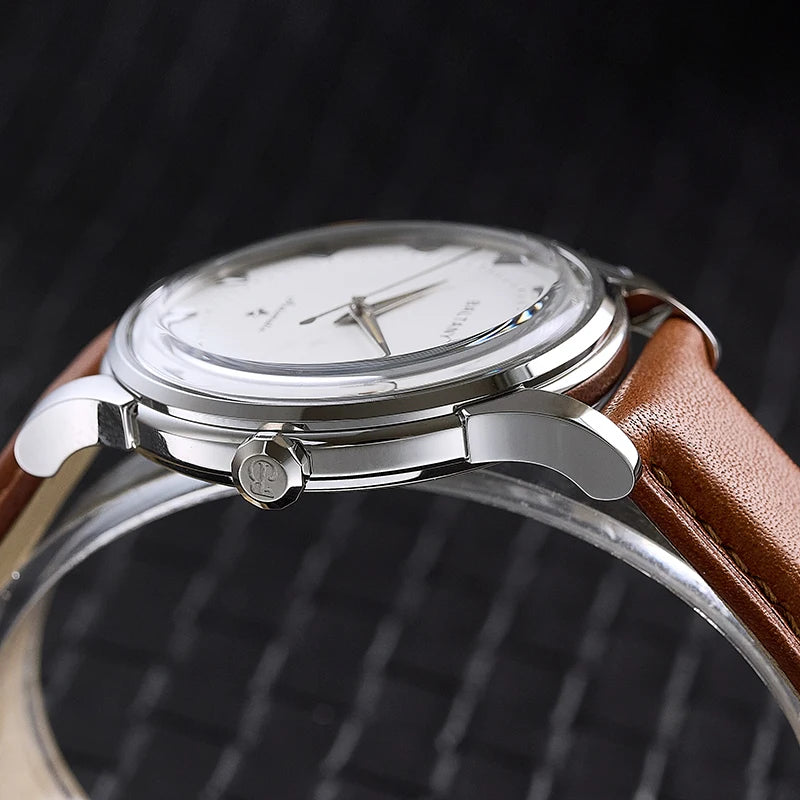 NorthChrono automatic watch featuring a round silver case and a white dial with simple hour markers and two hands. It has a brown leather strap and a crown for time adjustment, set against a textured black background.