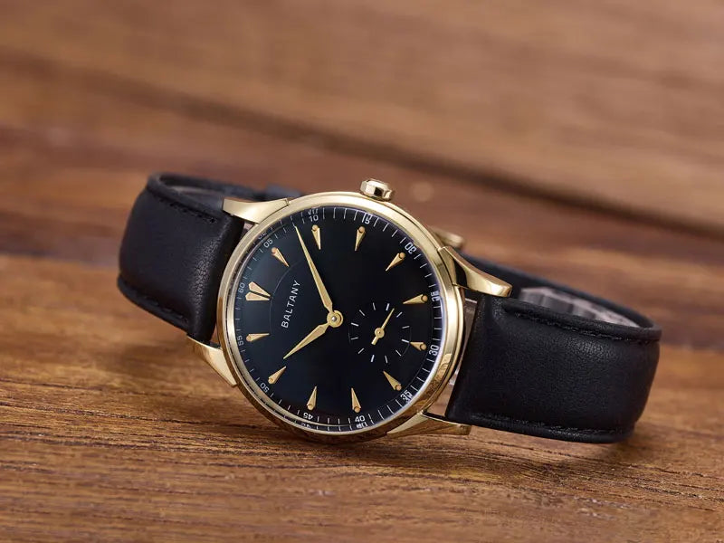 NorthChrono classic wristwatch with a black dial, gold accents, and hour markings. It features a round stainless steel case and a black leather strap, showcasing an elegant design suitable for formal occasions.