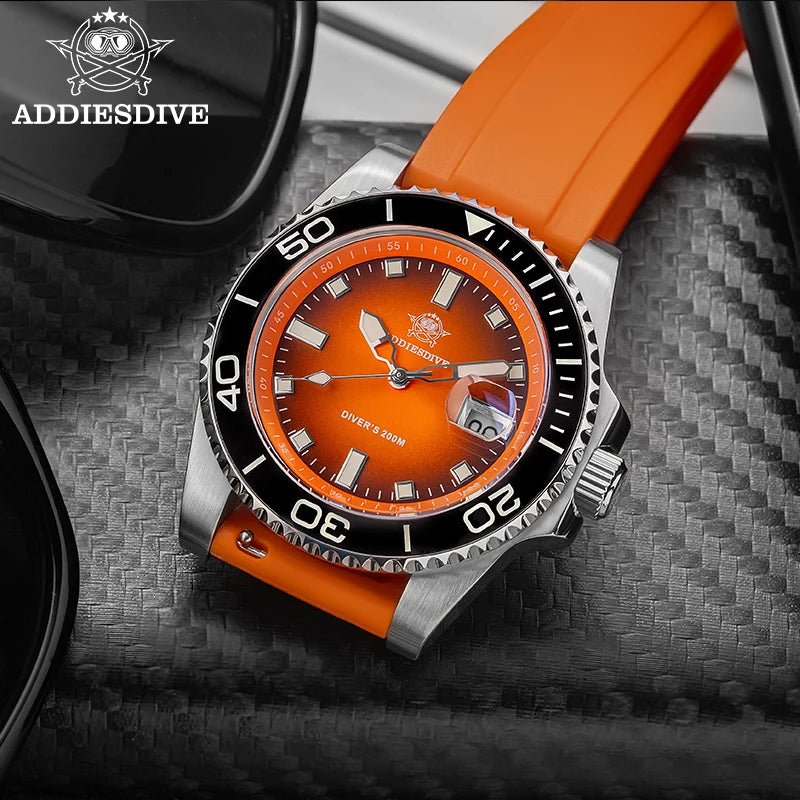 NorthChrono diver's watch featuring an orange dial, stainless steel case, and black bezel with minute markings. It has an orange rubber strap and is accompanied by sunglasses on a textured surface, likely carbon fiber.