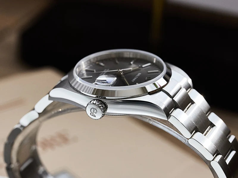 NorthChrono stainless steel watch with a dark dial featuring silver hour markers and a date window at 3 o'clock. The design includes a side crown for time adjustment, showcasing an elegant and sophisticated style.