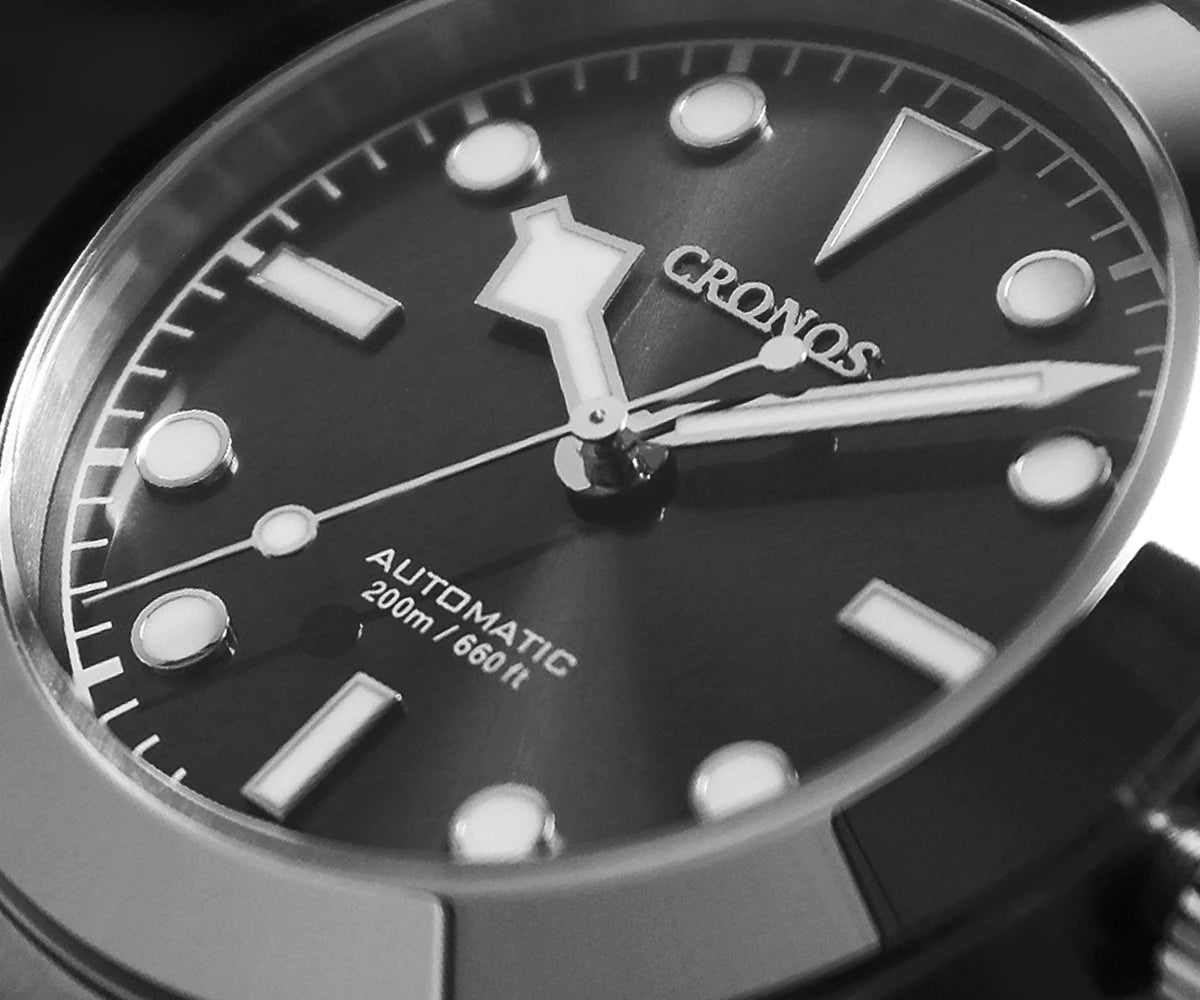 NorthChrono automatic sports watch close-up featuring a black dial with silver hour markers and white hands, marked for 200 meters water resistance, displayed against a dark background.