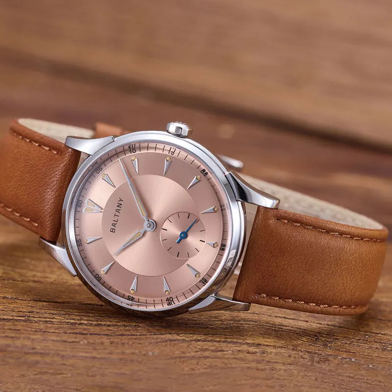 NorthChrono elegant round silver case watch features a rose gold-tone dial with hour markers and a blue-hand subdial, complemented by a brown leather strap, showcasing a classic design suitable for any occasion.