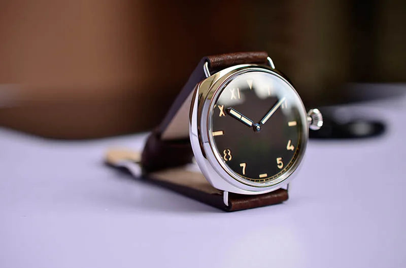 NorthChrono round metallic watch featuring a dark dial with simple hour markers and hands, complemented by a brown leather strap, designed for casual or formal wear.