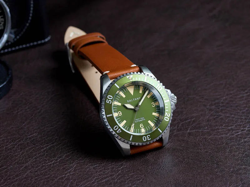 NorthChrono diver's watch with green dial, rotating bezel, and brown leather strap, displayed on a textured brown surface, emphasizing its rugged design. Ideal for underwater adventures, blending functionality with classic style.