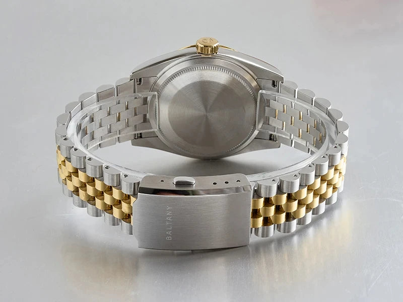 NorthChrono stainless steel watch with a polished finish, featuring a gold crown and a two-tone bracelet combining stainless steel and gold links. The caseback is smooth, showcasing a secured clasp and sleek design.