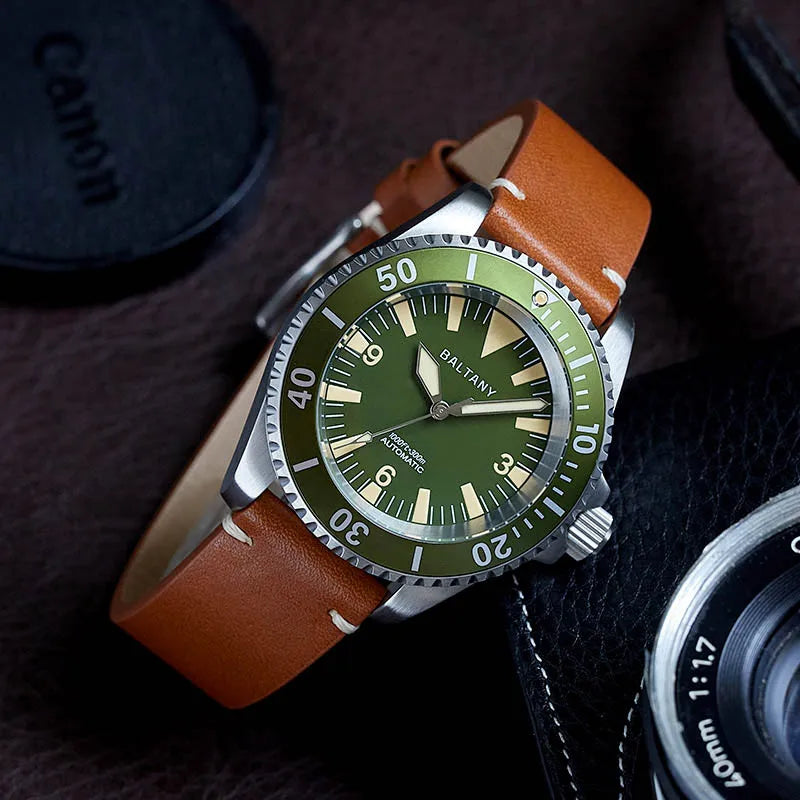 NorthChrono dive watch featuring a green dial, stainless steel case, and light brown leather strap, positioned on a textured surface beside a camera lens cap, emphasizing a stylish thematic presentation.