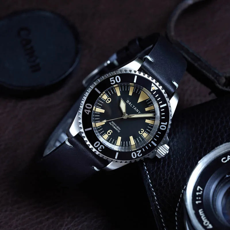 NorthChrono classic diving watch with a black dial, prominent hour markers, and luminous hands, featuring a unidirectional rotating bezel. The watch is paired with a brown leather strap, set against a dark background with a Canon camera lens cap.