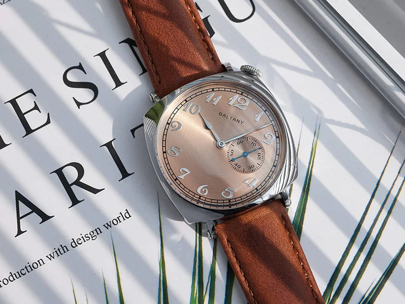 NorthChrono watch with a polished round face featuring large Arabic numerals and a small subdial, set on a brown leather strap, resting on a book with design-related text, casting soft shadows in natural light.