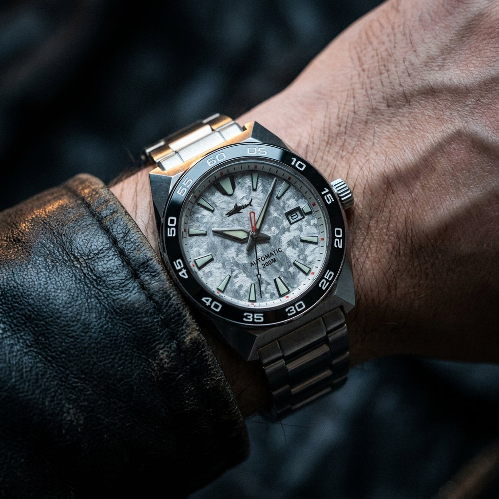 NorthChrono men's wristwatch featuring a textured silver and grey dial with hour markers and date function, secured by a silver metal band, partially covered by a black leather jacket.