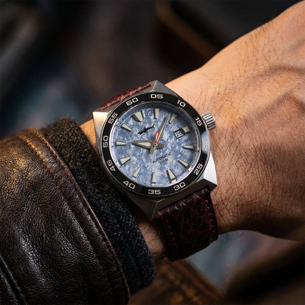 NorthChrono stainless steel watch with a blue dial featuring large hour markers, date function, and luminous hands, mounted on a textured brown leather strap, resting against a dark, textured surface.