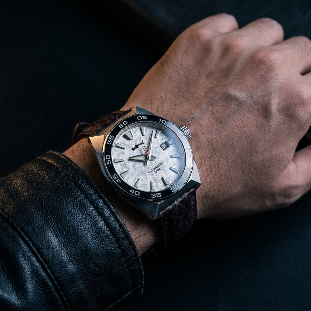 NorthChrono close-up of a wristwatch featuring a silver case and a white dial with black accents, indicating time and date, paired with a brown leather strap against a dark background.